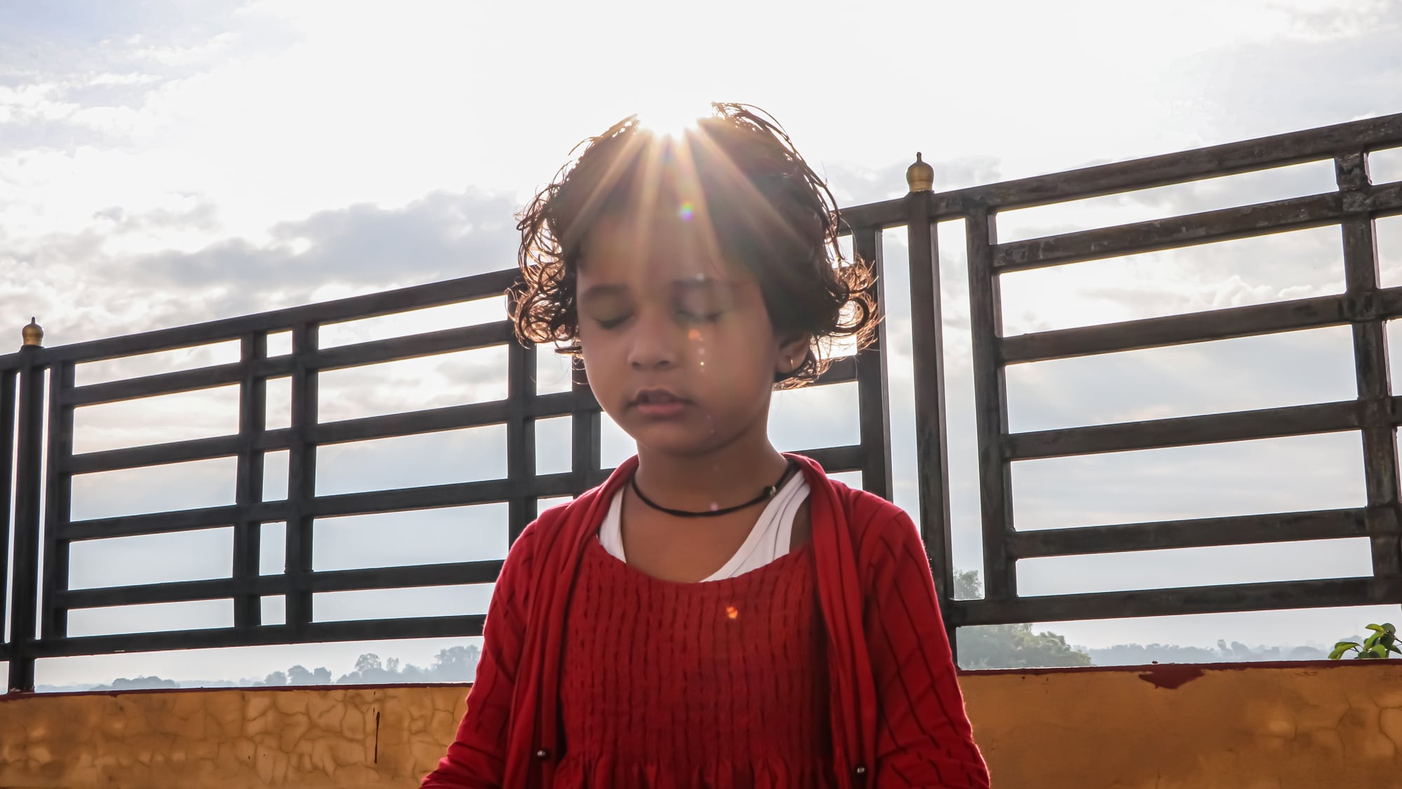 child in red sweater meditating